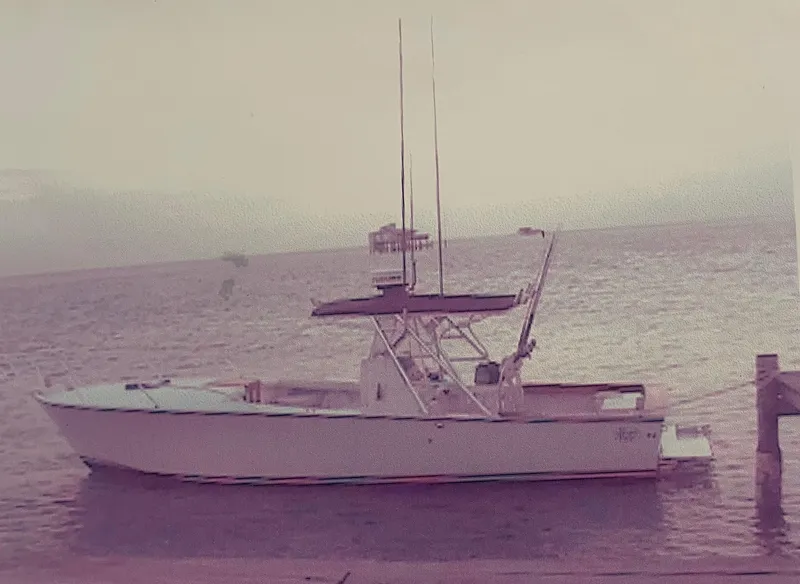 2000 Stuart Angler 32 Center Console boat docked by the sea.