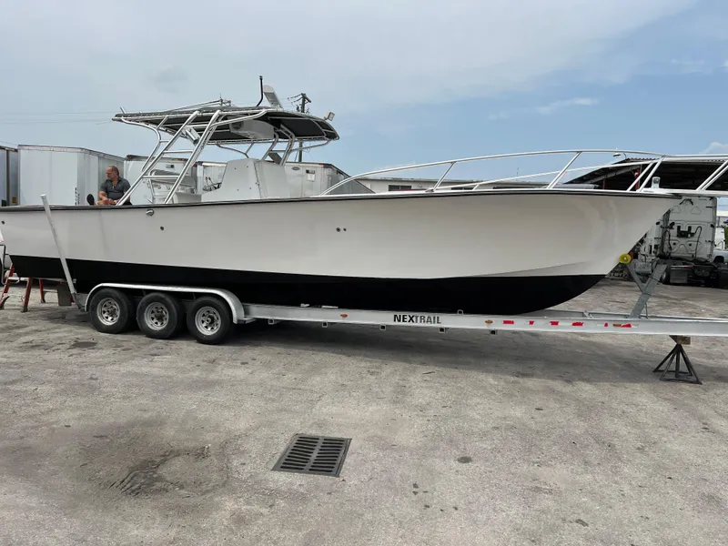 2000 Stuart Angler 32 Center Console/Cutty boat on trailer, parked outdoors.