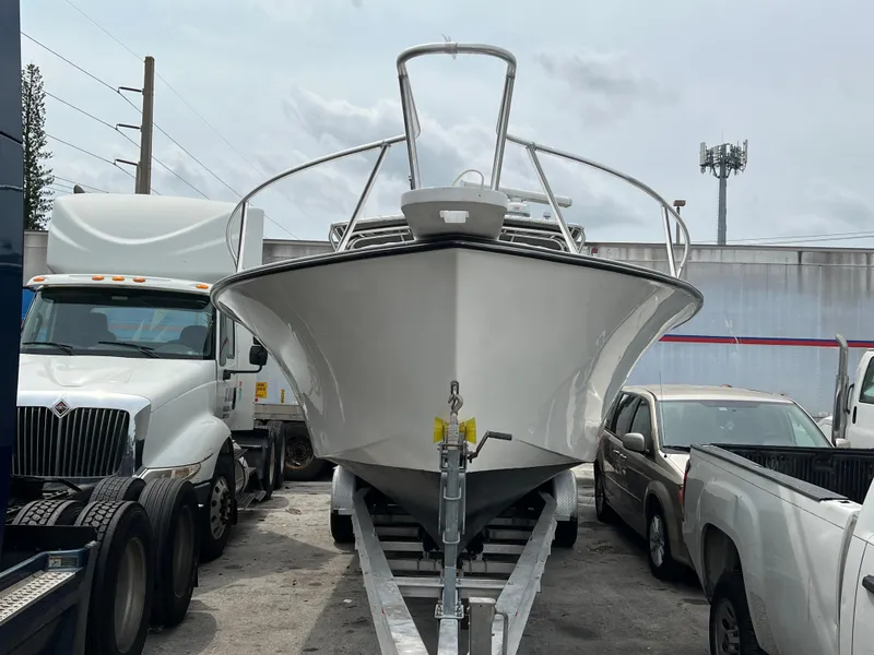 2000 Stuart Angler 32 Center Console boat on trailer, surrounded by trucks.