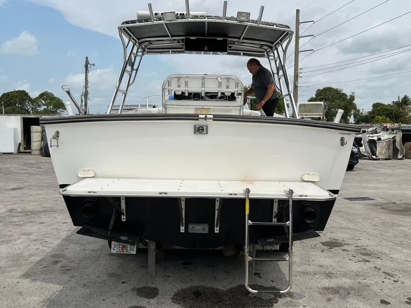 2000 Stuart Angler 32 Center Console boat with ladder, docked on concrete surface.