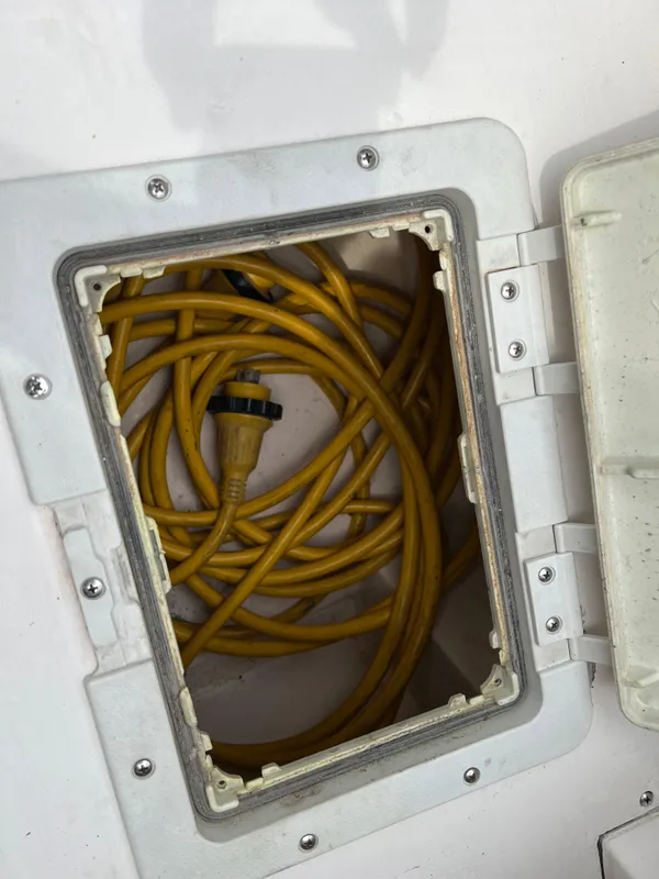 Yellow power cable stored in a compartment of a 2000 Stuart Angler 32 Center Console/Cutty.