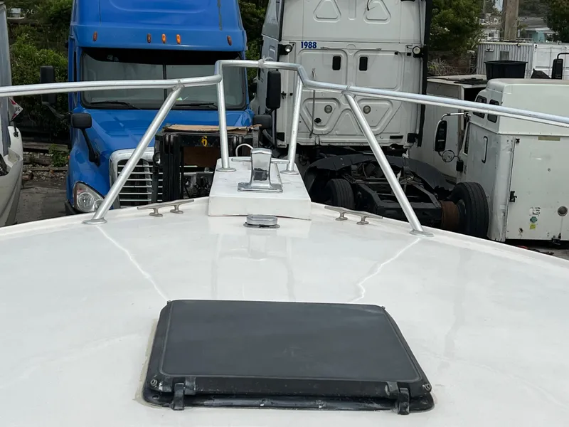 Bow view of 2000 Stuart Angler 32 Center Console boat, parked near trucks.