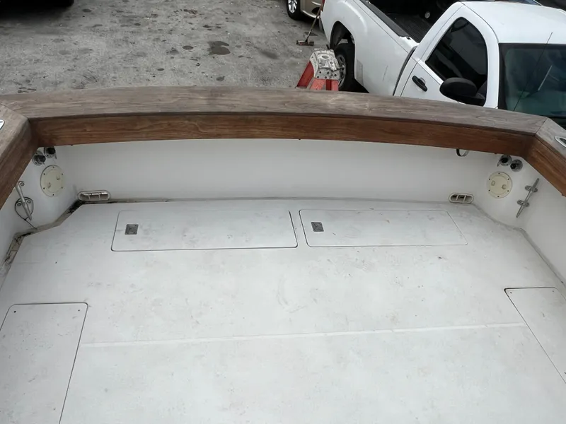 2000 Stuart Angler 32 Center Console boat deck with wooden railings and storage compartments.