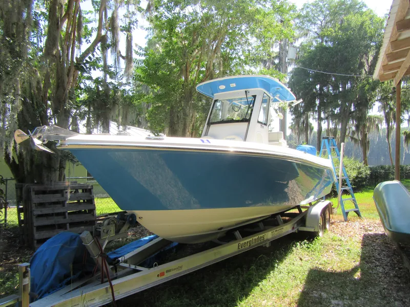 2017 Everglades 255 Center Console boat on trailer in a wooded area.