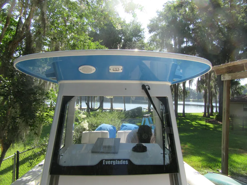 2017 Everglades 255 Center Console boat with blue hardtop in a scenic lakeside setting.