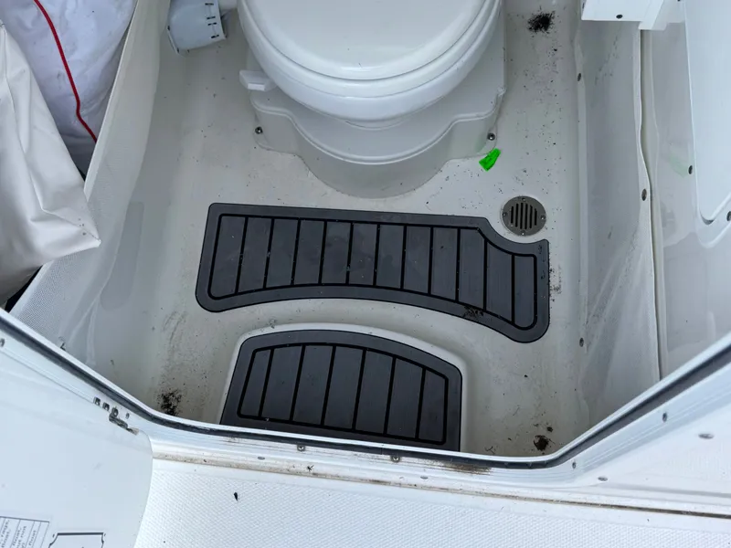 2024 Sea Hunt Gamefish 25 boat toilet with non-slip mats.