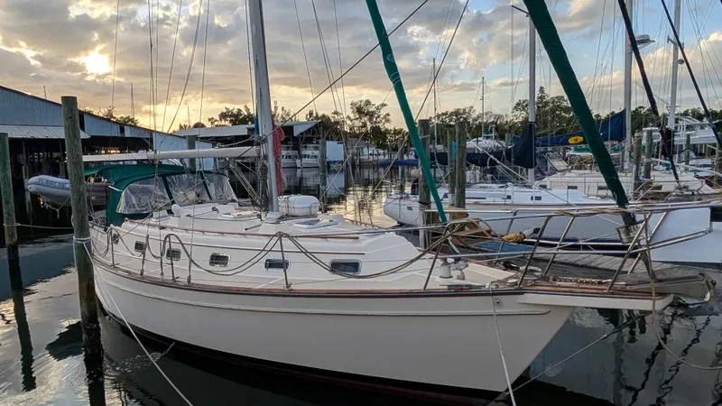 1998 Island Packet 40 sailboat docked at marina during sunset.