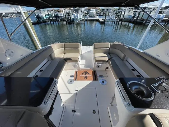 Interior of a 2014 Regal 3550 Cuddy yacht with seating area and sink.