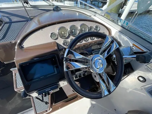 Cockpit of a 2014 Regal 3550 Cuddy boat with shiny steering wheel.