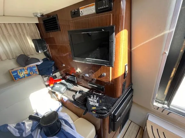Interior of a 2014 Regal 3550 Cuddy boat with TV and seating area.