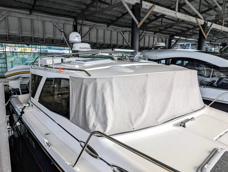 2022 Cutwater C-32 Coupe LE boat docked under a covered marina.