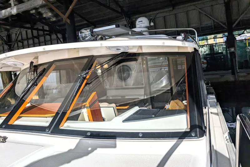 2022 Cutwater C-32 Coupe LE boat docked under a covered structure.