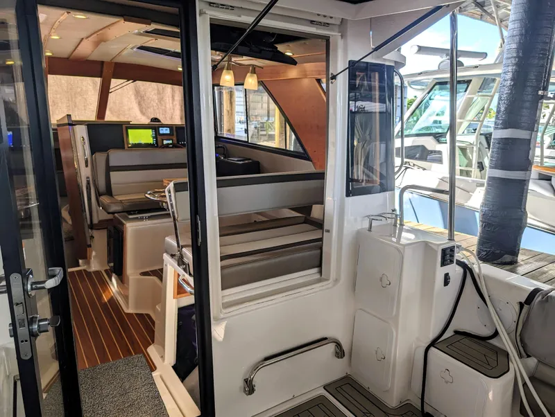 Interior view of 2022 Cutwater C-32 Coupe LE boat, featuring seating and navigation area.