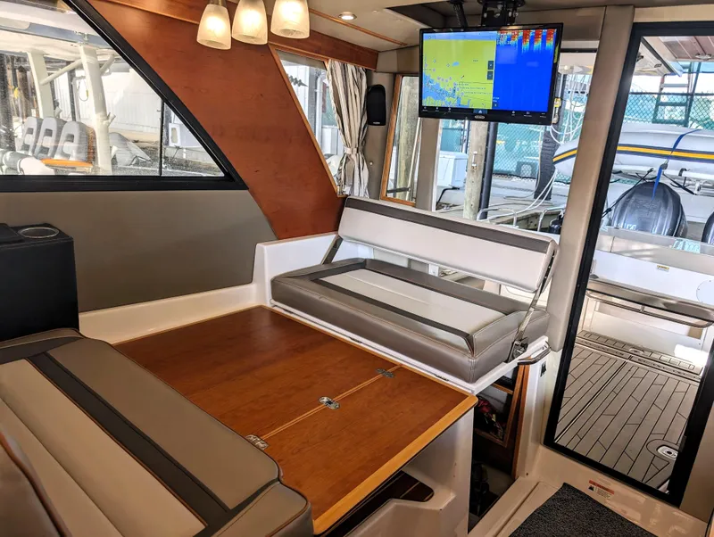Interior of 2022 Cutwater C-32 Coupe LE with seating, table, and navigation screen.